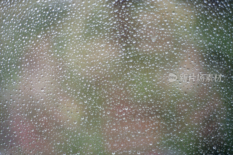 一场阵雨中，成千上万的雨滴落在玻璃上