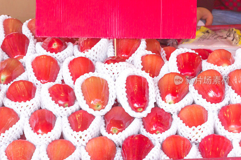 一堆打蜡的巨型玫瑰苹果在泰国的新鲜市场作为背景