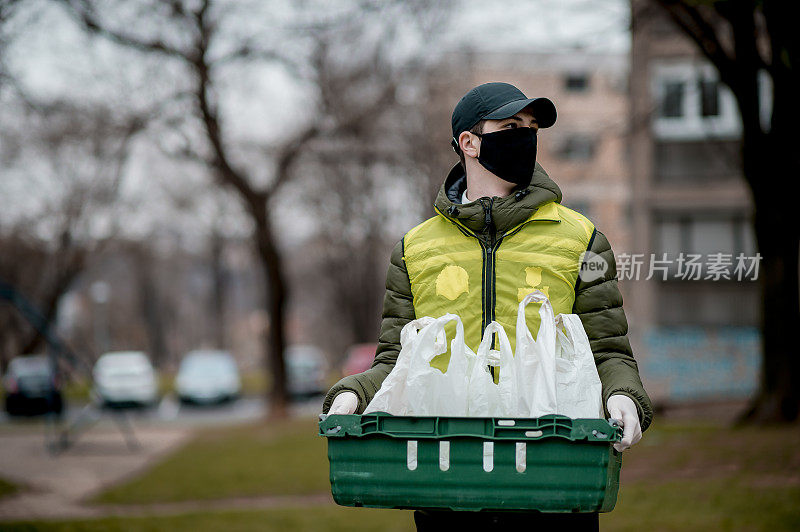 年轻的送货员戴着防护面具和防护手套