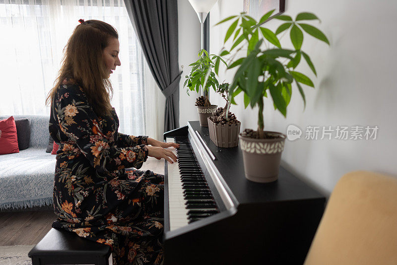 一位钢琴家在自己家里的房间里谱曲