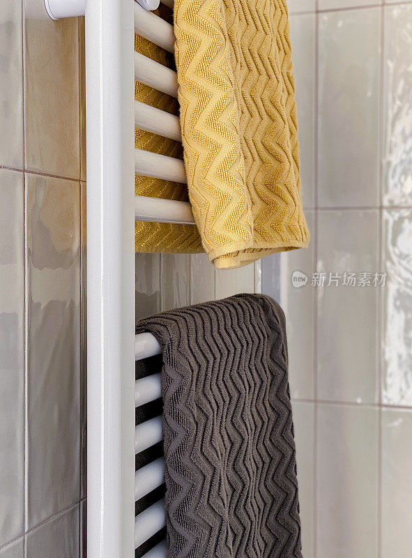 毛巾摆放在浴室毛巾架上，颜色对比鲜明