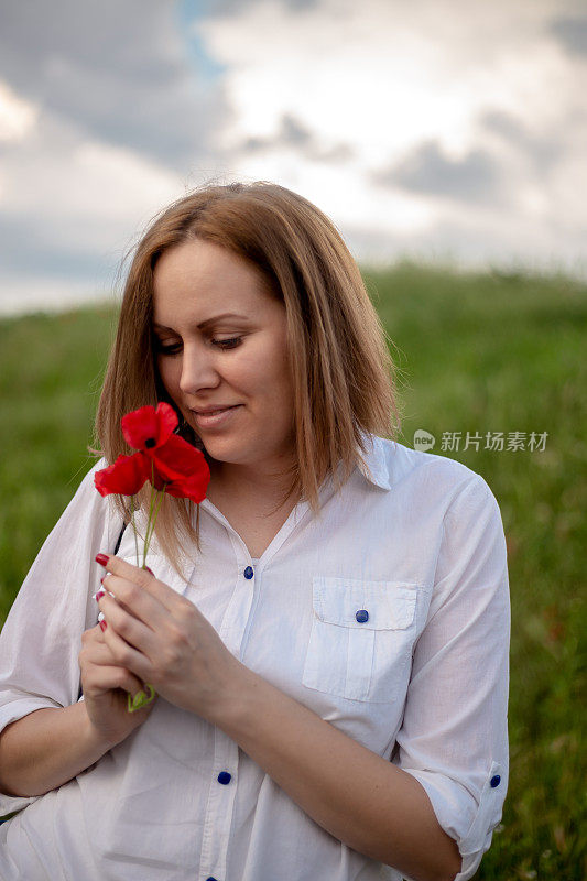 女人拿着罂粟，普通的罂粟，红色的花