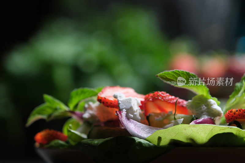 用新鲜菠菜、莴苣、草莓和羊乳酪制作健康沙拉