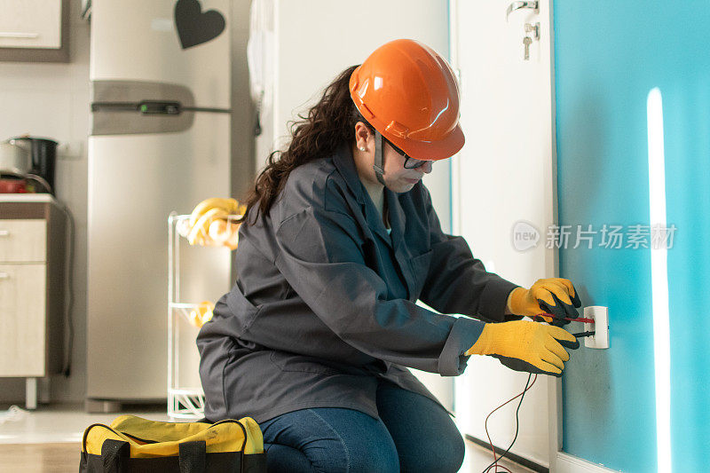 女电工用万用表检查电。