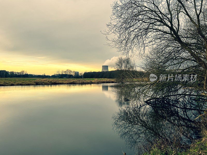 这条名为“Ems”的河在冬天的傍晚，背景是一座核电站。