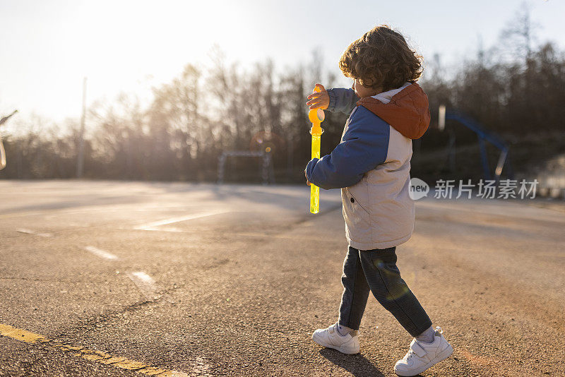 顽皮的白人学步男孩，制造肥皂泡