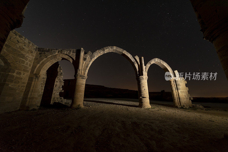 夜晚，中世纪教堂的拱门废墟被星光照亮