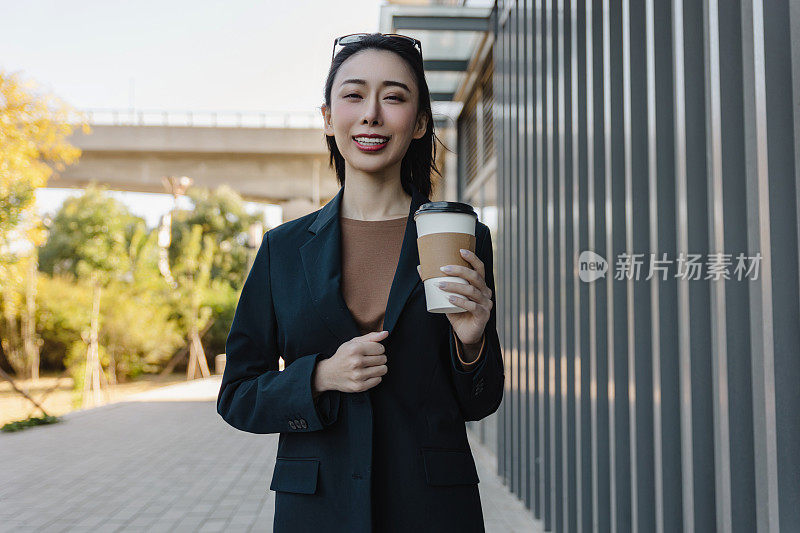 成功的女经理走在城市的街道上。