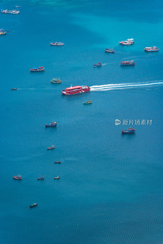 越南孔岛本丹港，湛蓝的大海，蓝天山和五颜六色的船只。