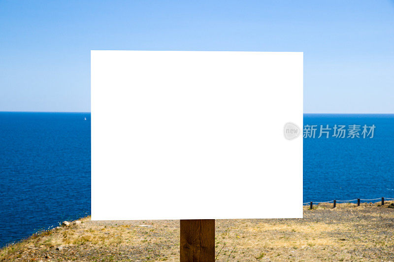 一个白色空广告牌的特写镜头对着蓝色的大海