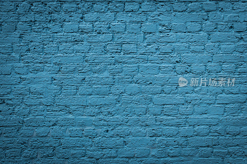 一堵空的蓝色砖墙，带有浓重的天蓝色