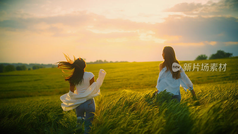 夕阳下，无忧无虑的年轻女子站在田间的庄稼中