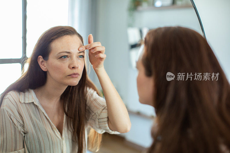 年轻女子在家里照镜子