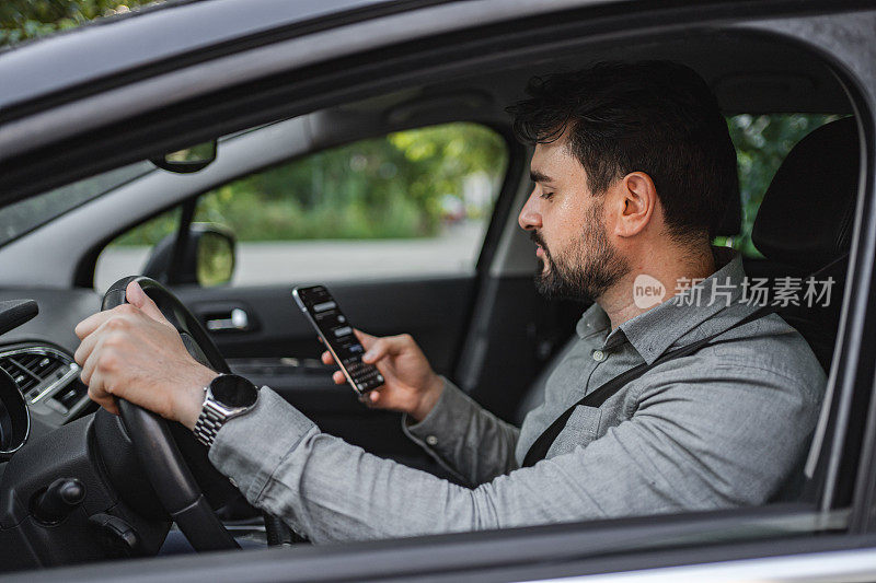 白人商人在开车上班的路上发短信