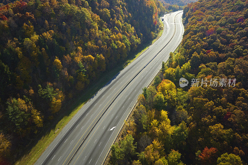 通往北卡罗来纳州阿什维尔的I-40高速公路上空无一车，这条公路穿过阿巴拉契亚山脉和黄色的秋天森林。高油价与能源危机的概念