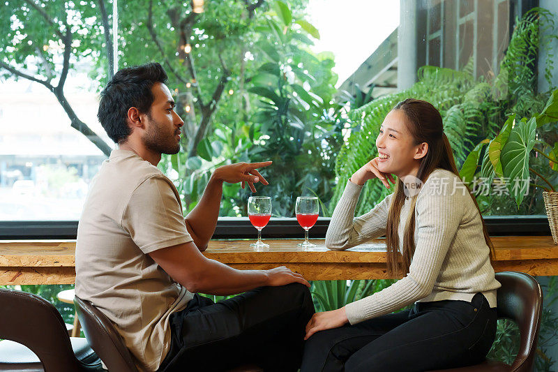 一对亚洲夫妇和一个年轻男子信仰印度。他们坐在餐厅的玻璃窗旁，喝着酒，夫妻俩讨论着各种各样的问题。快乐地追寻过去的故事