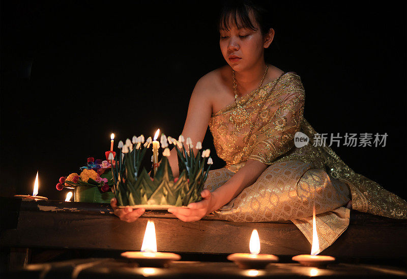 一名年轻女子在泼水节当天穿着黑色背景的古老泰国服装