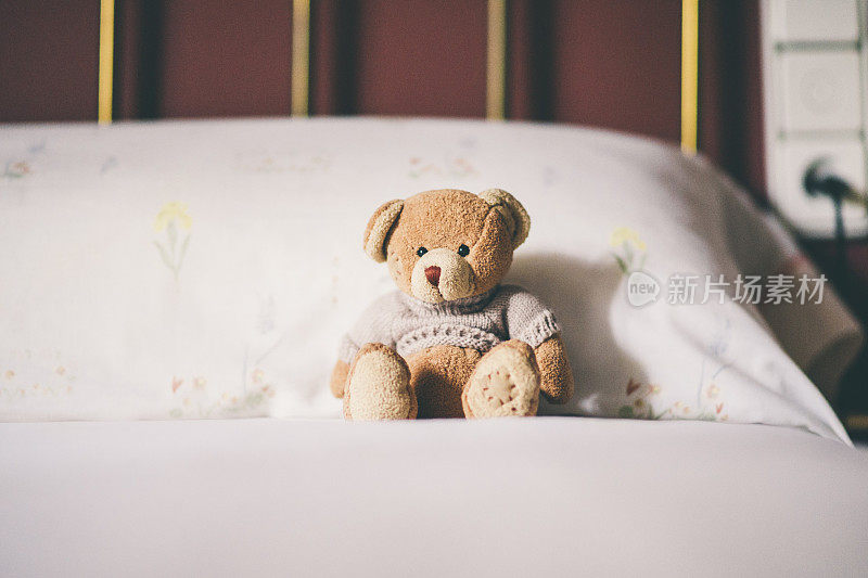 泰迪熊在床上，给文字留出空间。
