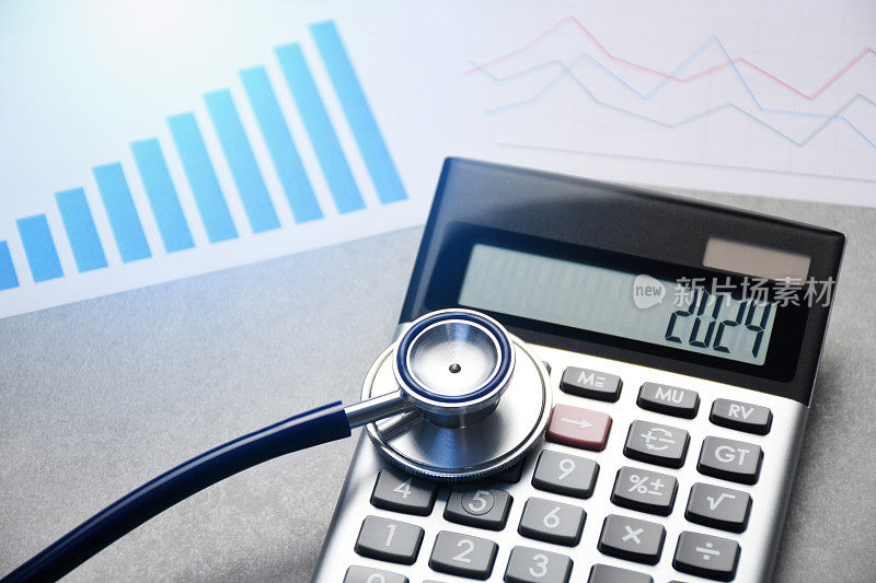 2024年新年医疗保健和医药预算概念。2024年的计算器显示器上有听诊器和财务文件。医疗保险价格