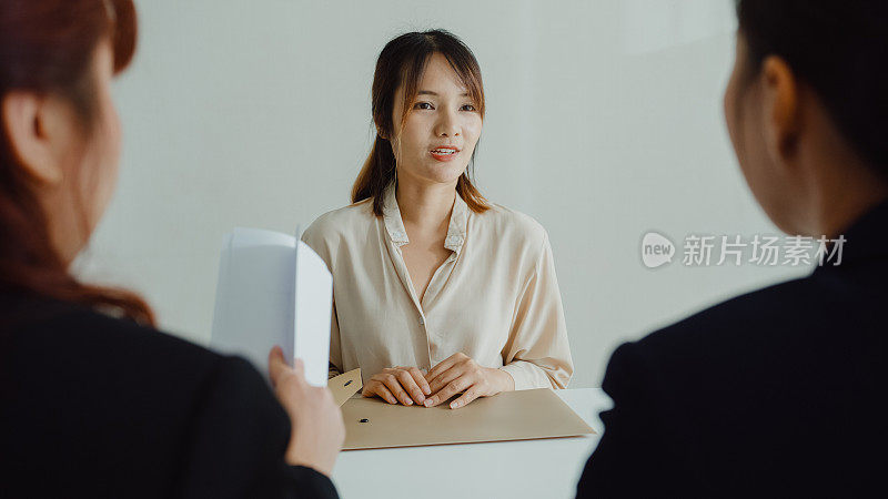 年轻的亚洲女性通过面试，坐在办公室的人力资源经理面前。人力资源，招聘机构。