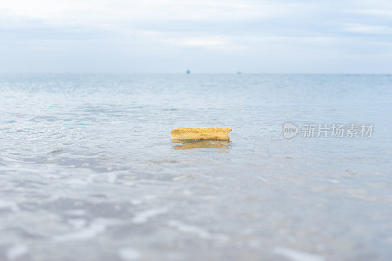 漂浮在海面上的黄色塑料泡沫，由于人类不当的废物处理而造成海洋污染。塑料泡沫破碎和降解导致微塑料的形成。