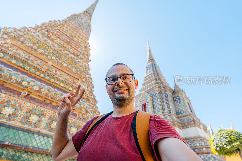 在泰国曼谷卧佛寺自拍的年轻人