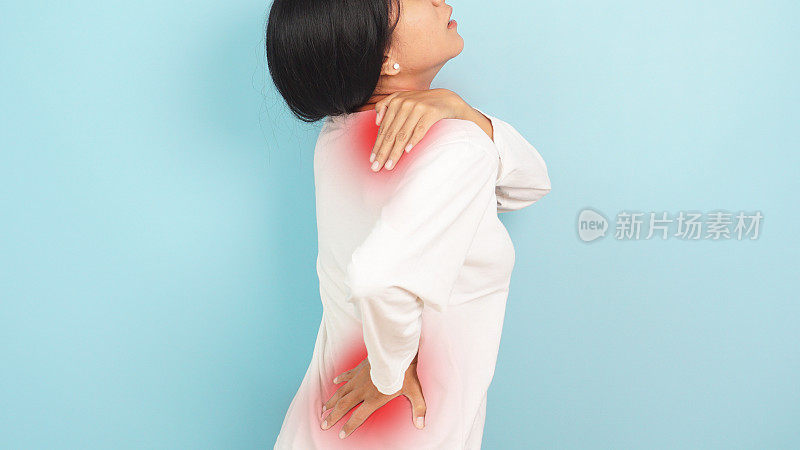 妇女的后视图与严重的背部和颈部疼痛，医疗问题，浅蓝色