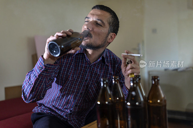 年轻悲伤的醉酒男子喝啤酒和酒精感到浪费，孤独和绝望的痛苦和情绪压力。人与酗酒、上瘾和男人抑郁的概念。