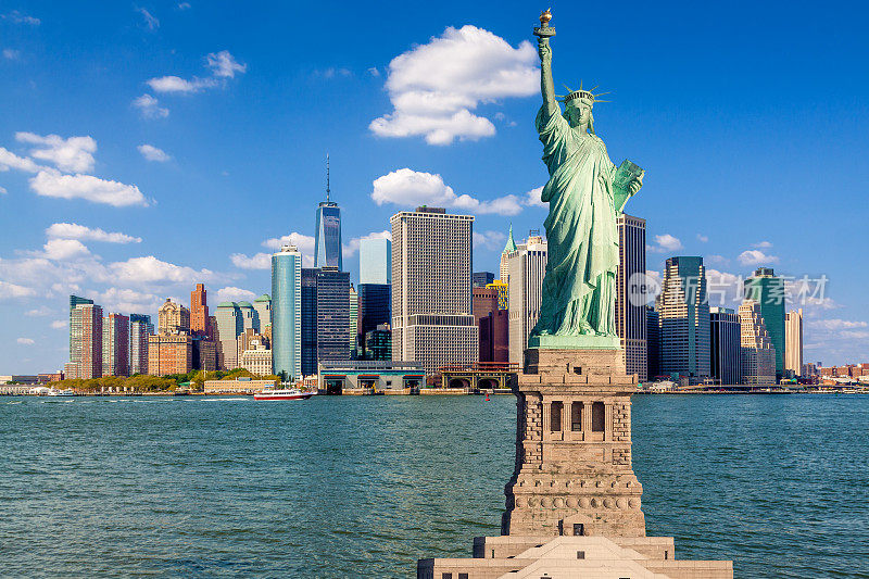 自由女神像和纽约城市天际线，曼哈顿金融区，世界贸易中心和纽约港水域，纽约，美国。