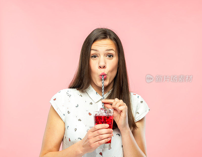 迷人的年轻女子喜欢用可重复使用的吸管喝冰茶