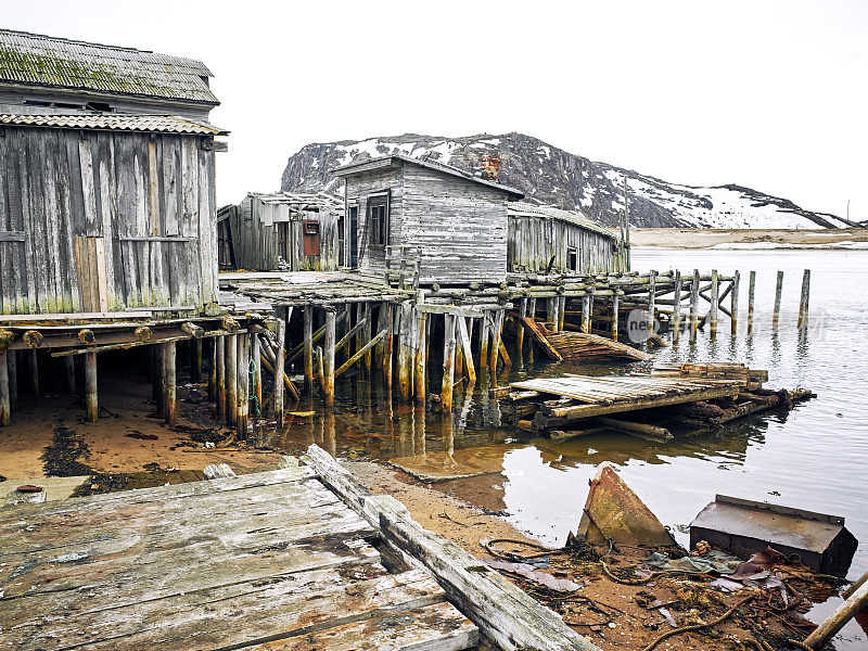 俄罗斯科拉半岛捷里别尔卡巴伦支海岸边，破旧的木码头和棚屋