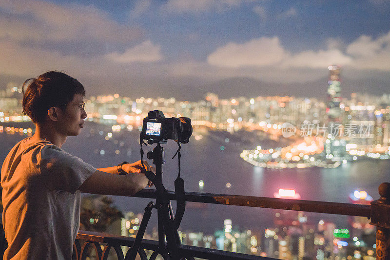 年轻的亚洲游客冒险拍摄香港的城市天际线在香港的famaus旅游胜地维多利亚峰