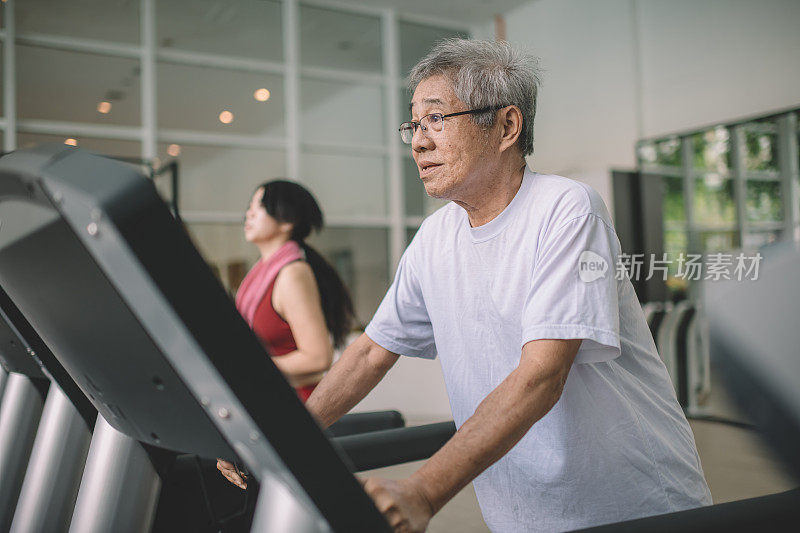 一位活跃的亚裔华人老人带着孙女在健身房锻炼