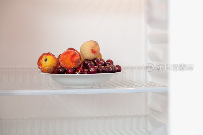 一套水果在空的打开的冰箱