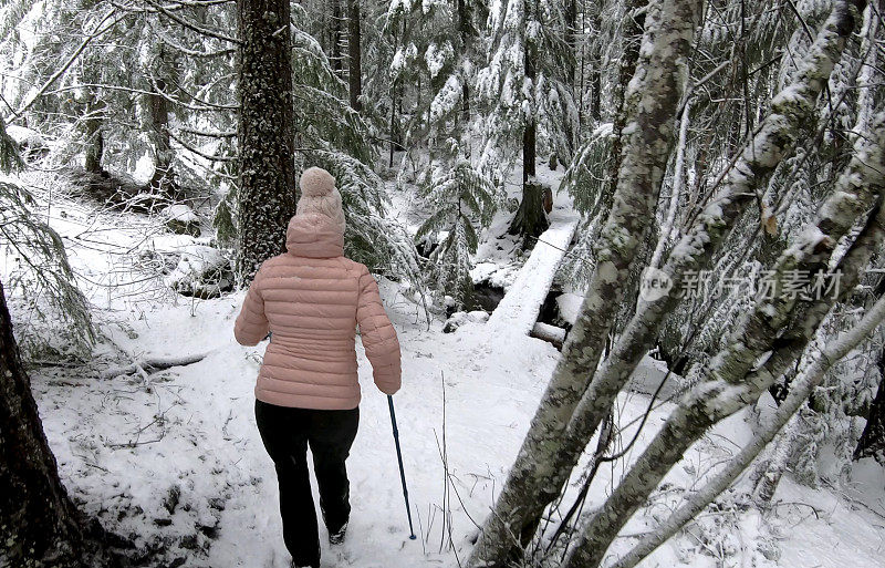 女性徒步旅行者沿着雪道行走