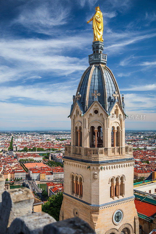 圣托马斯教堂鸟瞰图，从长方形圣母院的屋顶上看到金色的圣母玛利亚雕像，背景是法国里昂城市