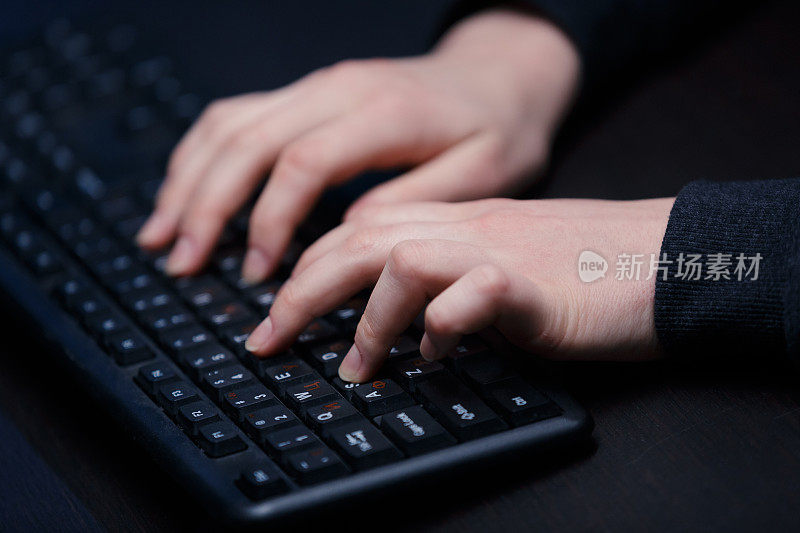 这是黑客在笔记本电脑上输入程序代码的双手特写。