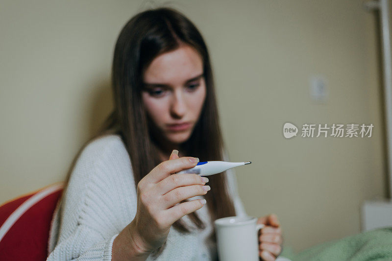 女病人躺在床上，盖着毯子