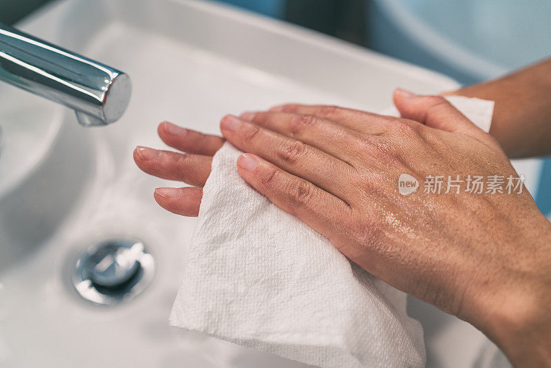 预防COVID-19疫情的个人卫生步骤:洗手后用纸巾擦干手。冠状病毒感染预防性清洁