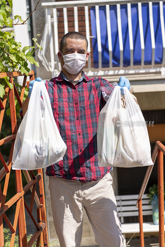 病毒爆发期间一名送货员正在把食品杂货送到一个被封锁的人那里