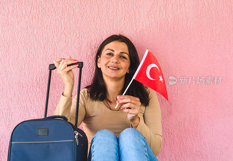 拿着旅行袋和土耳其国旗的女人