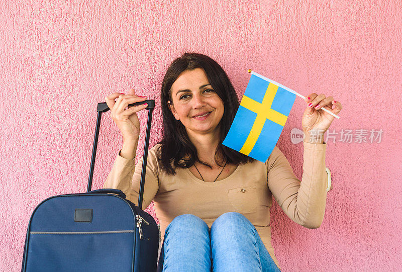 拿着旅行袋和瑞典国旗的女人