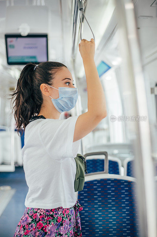 一名女子戴着无菌口罩乘火车旅行