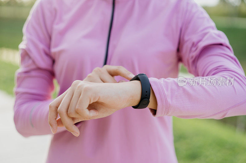 一位女士正在检查手腕上的健身追踪器