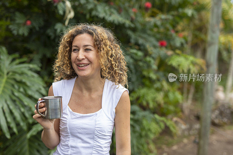 快乐的西班牙女人在家里喝杯茶放松