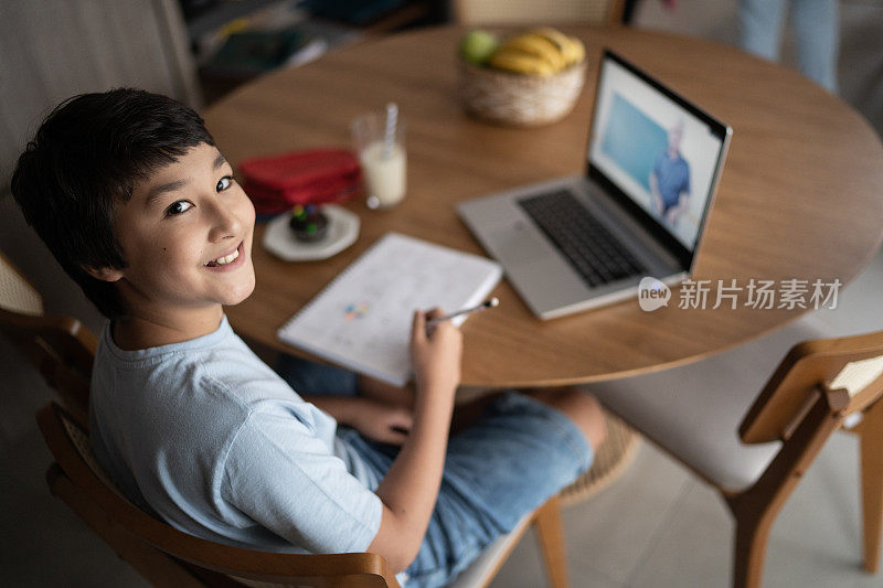 一个十几岁男孩在家学习的肖像