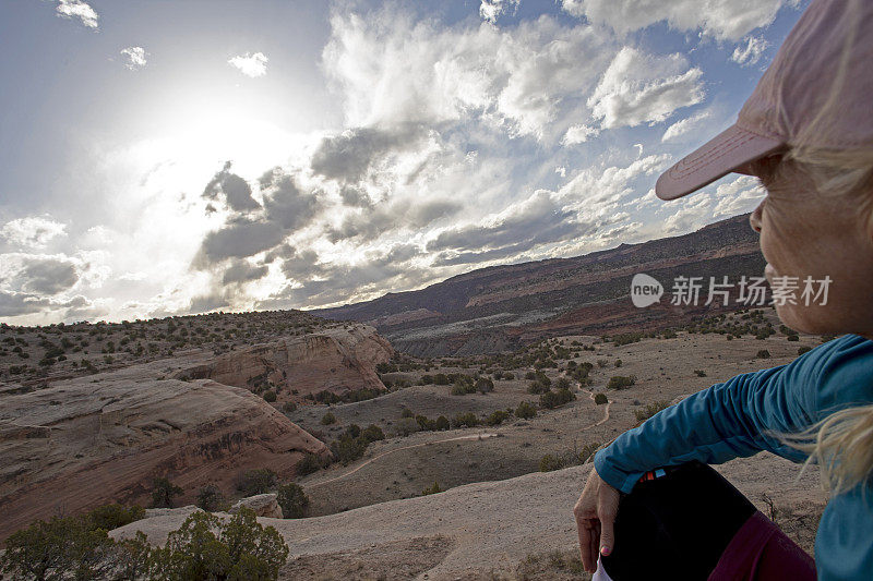 女徒步旅行者早上在山脊上休息