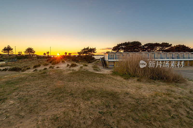 太阳落在多塞特的沙滩小屋上