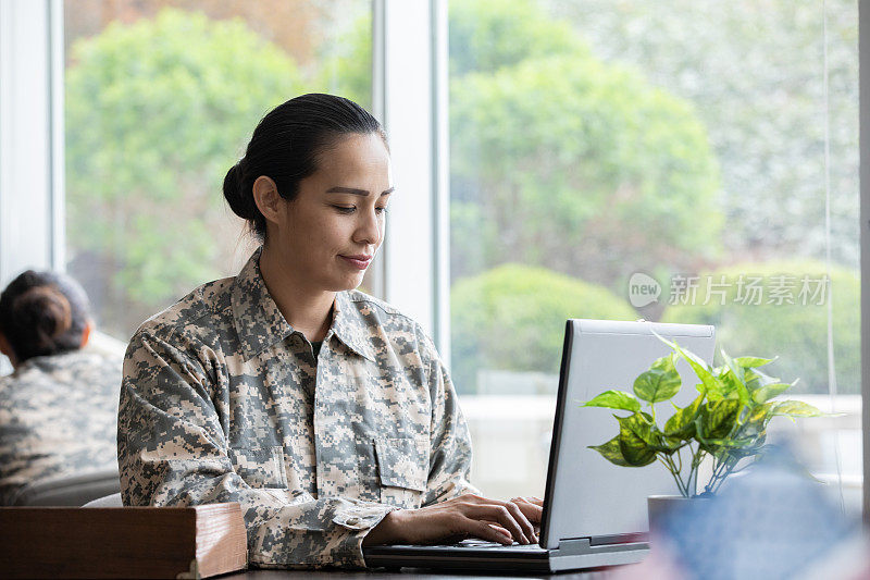 女兵从征兵办公室的笔记本电脑发送电子邮件