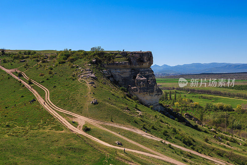 美丽的夏季景观，道路通往一个小悬崖与美丽的绿色山谷全景